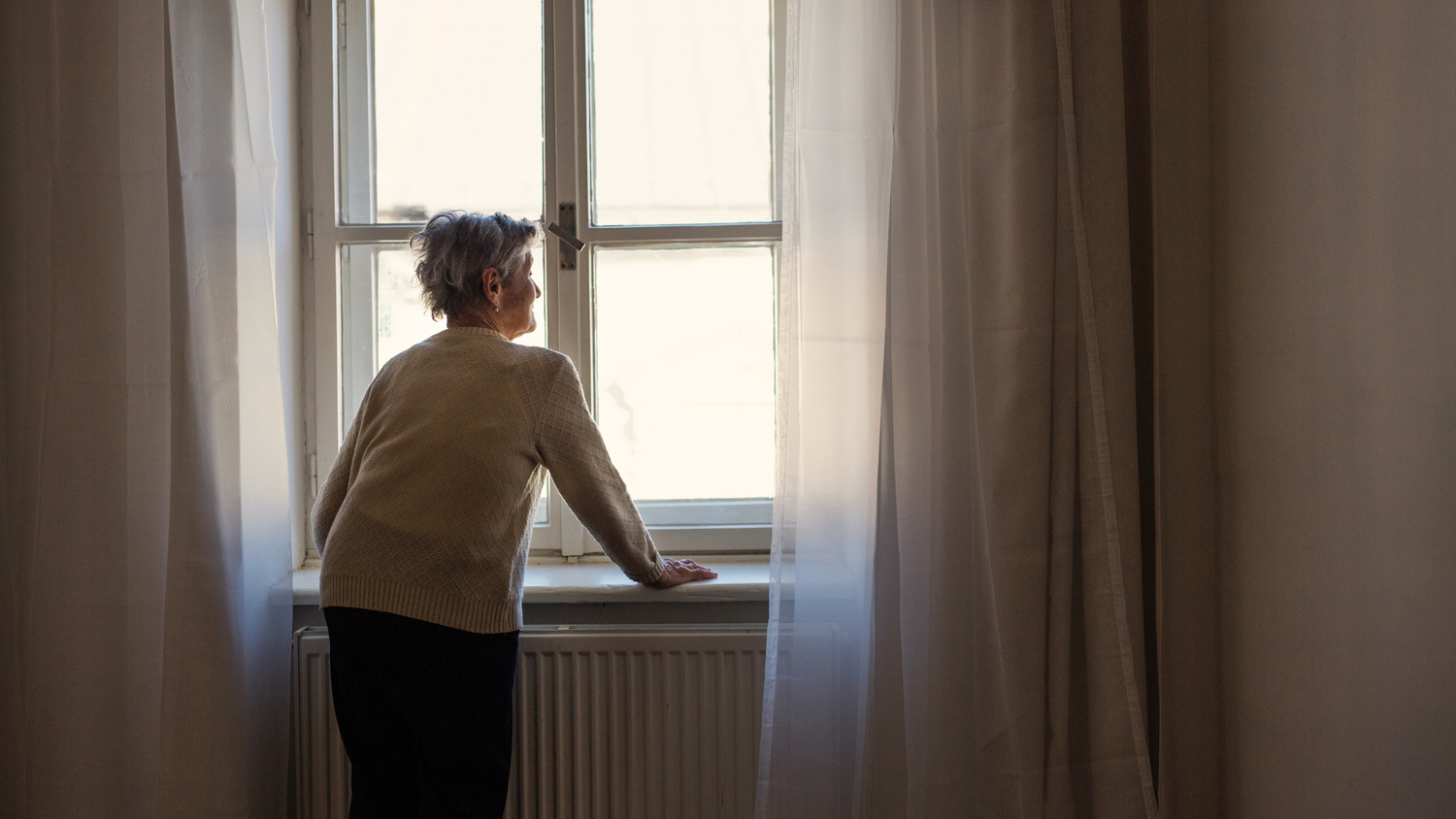 Gammel dame kikker ut av et vindu