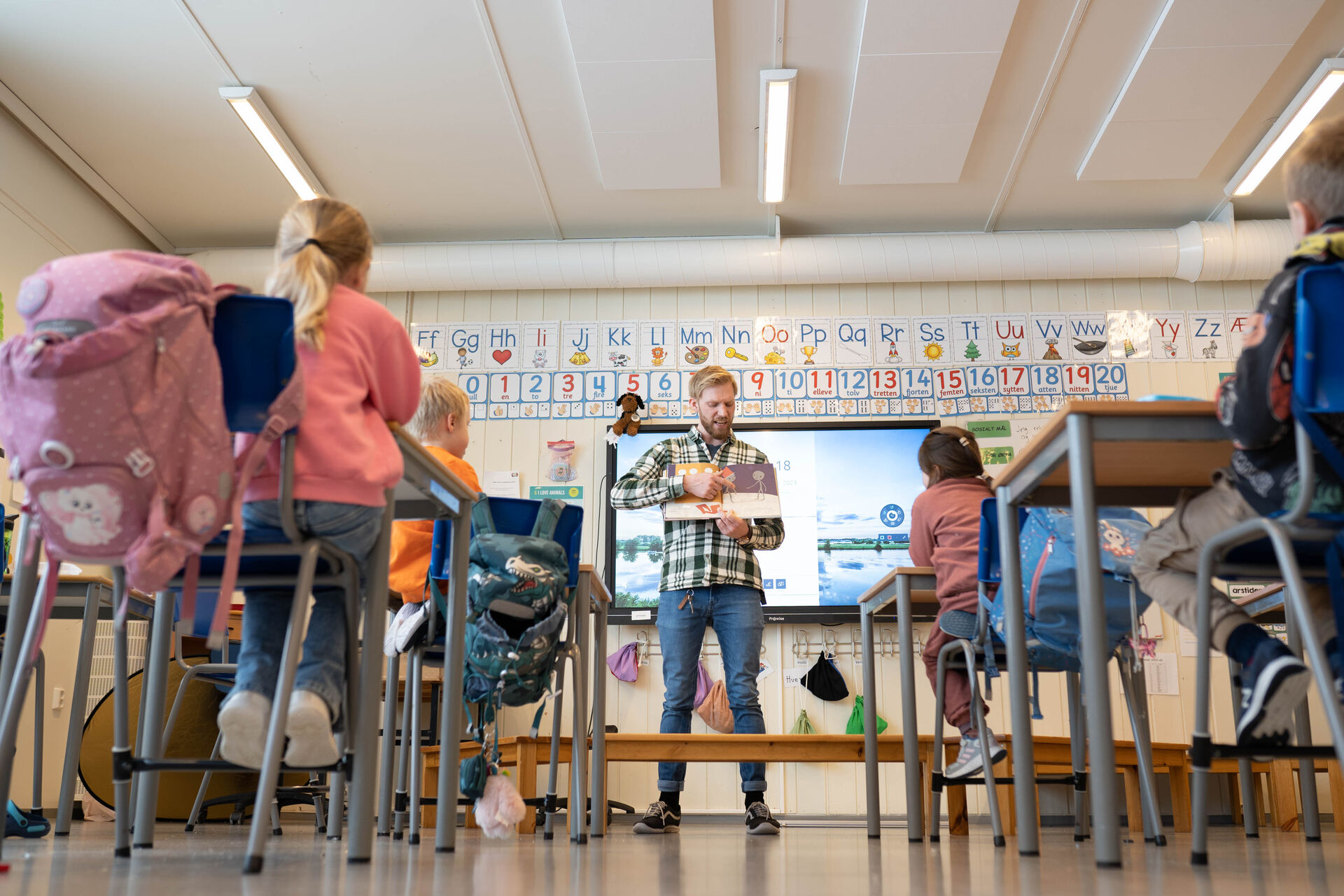 Bilde tatt bak i klasserommet mens elevene hører på Halvor som leser der fremme.