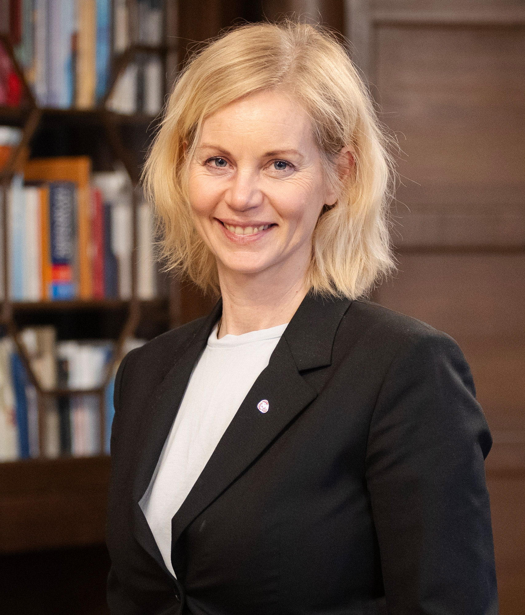 Dame medlyst hår og svart blazer i et bibliotek