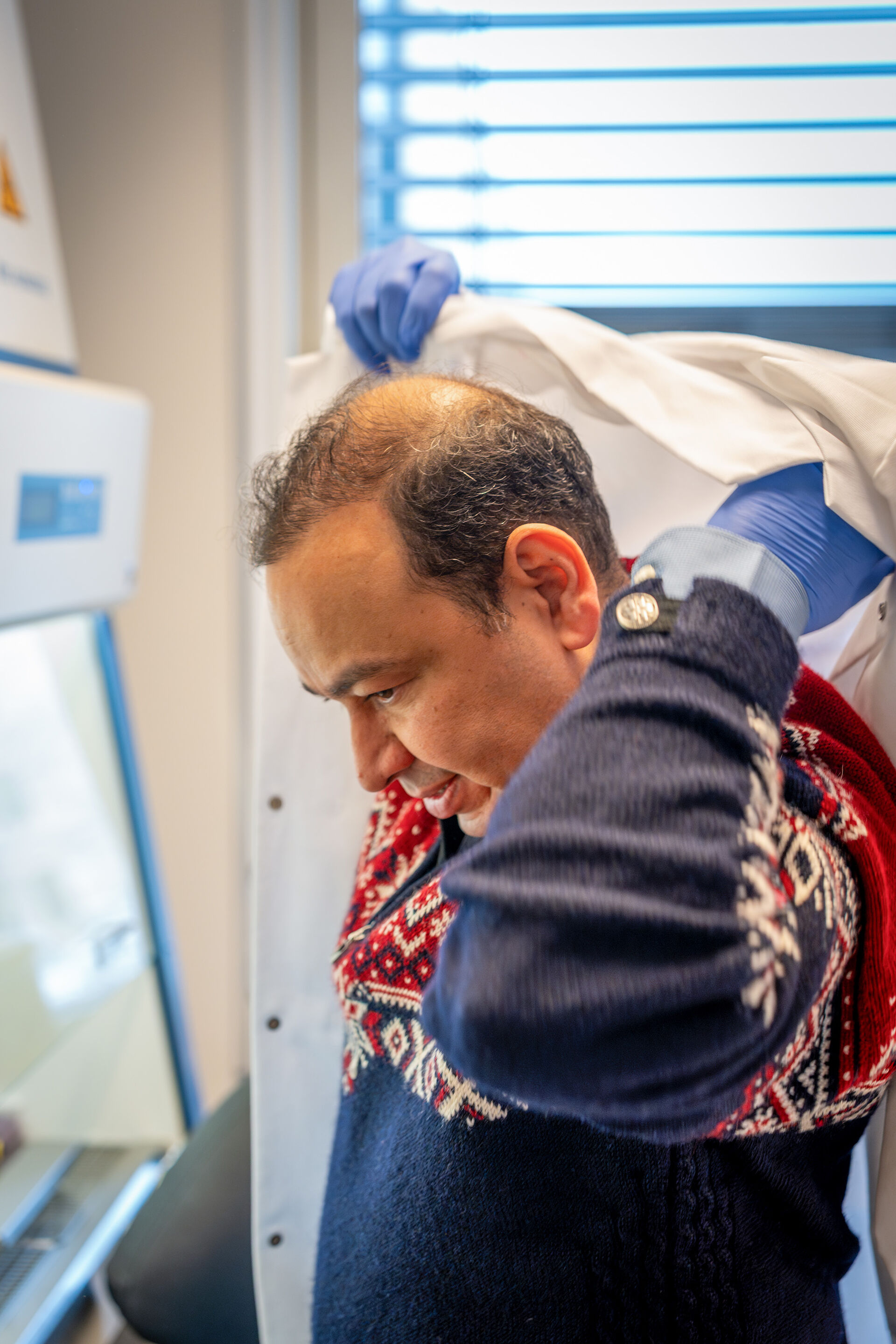 Rafi tar på seg lab frakken.