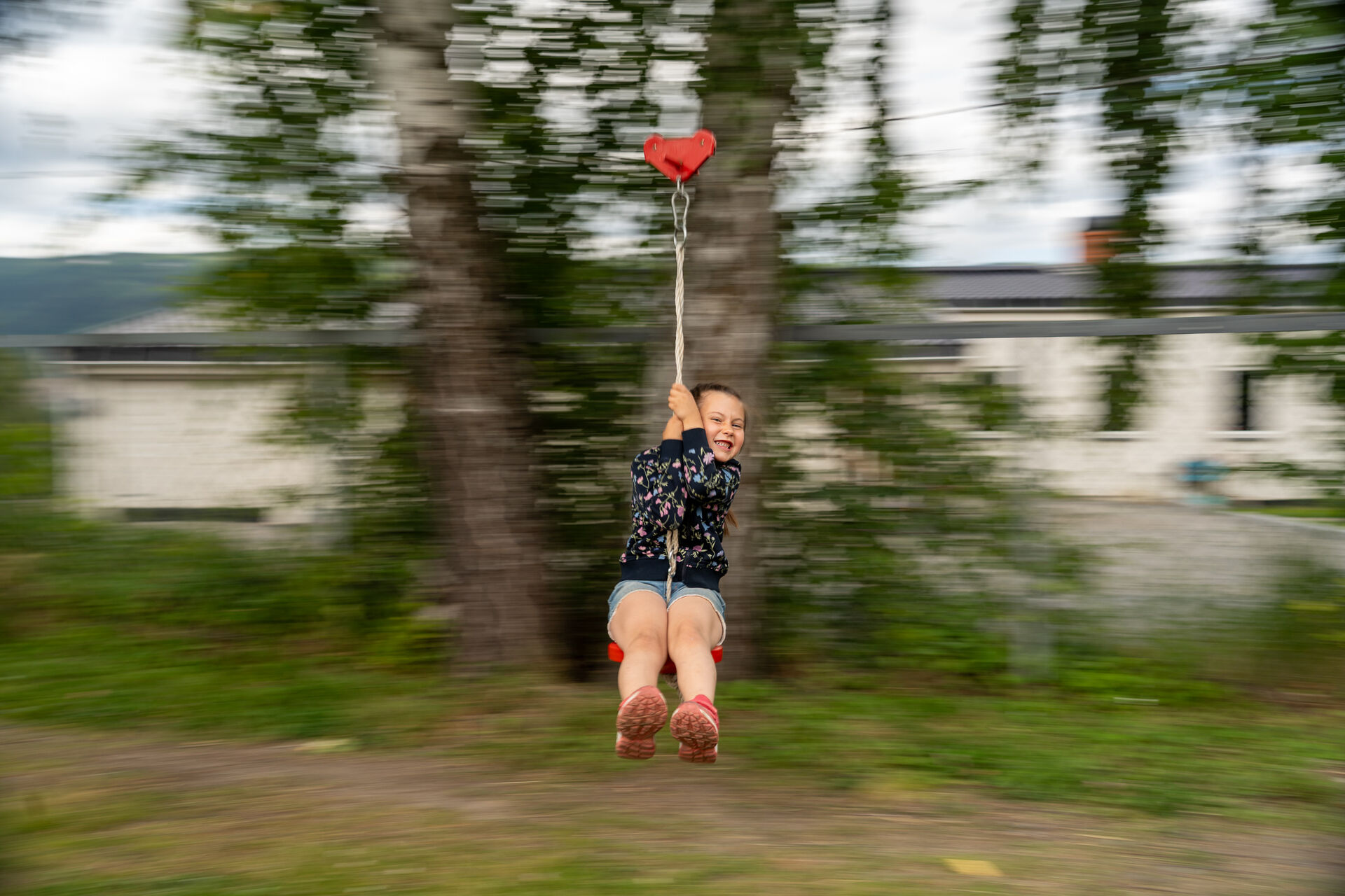 Erika susende forbi på en zipline mens hun smiler.