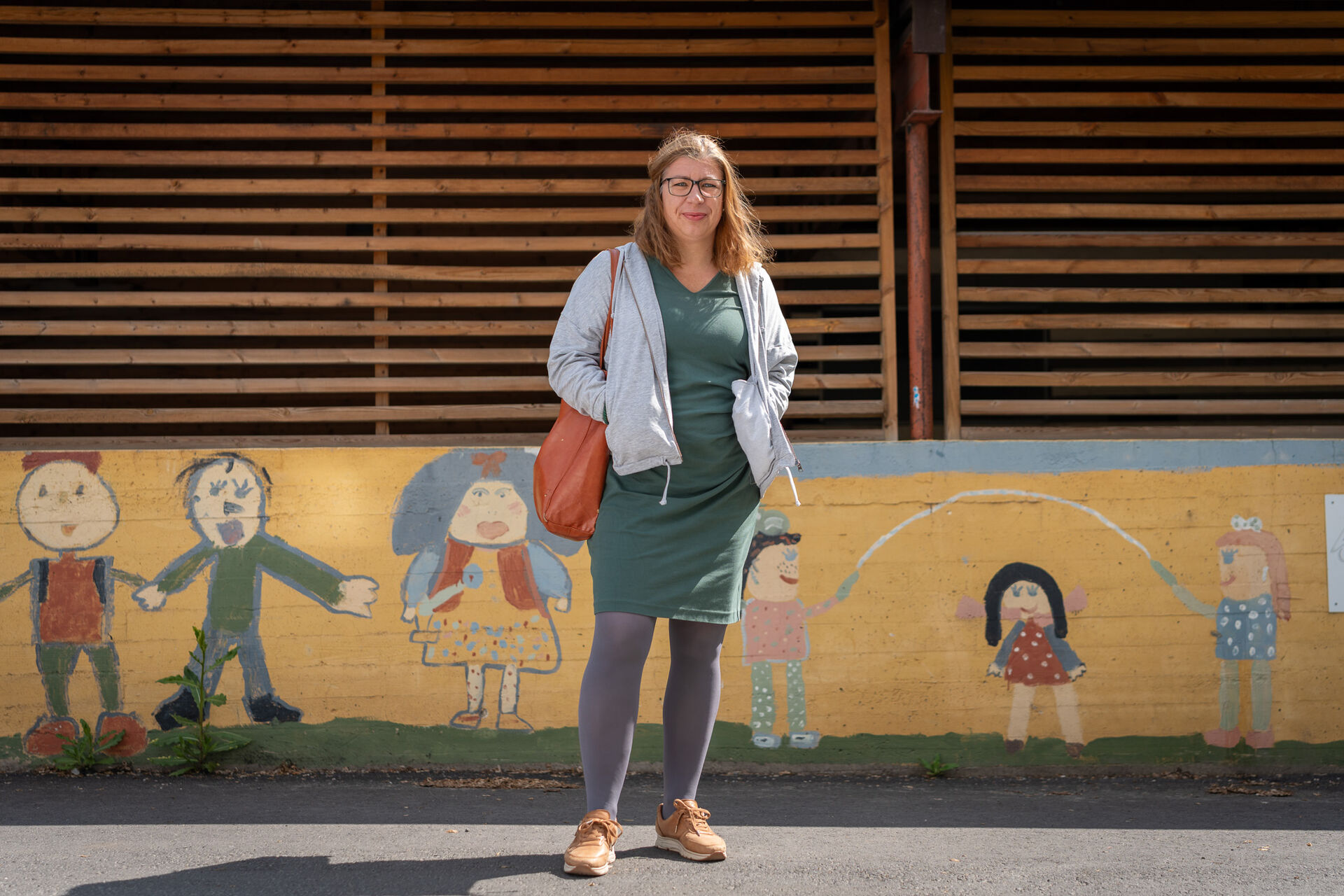 Portrett ute av Kristin D. Bergseth. Bakgrunnen er en malt murvegg på en barneskole.