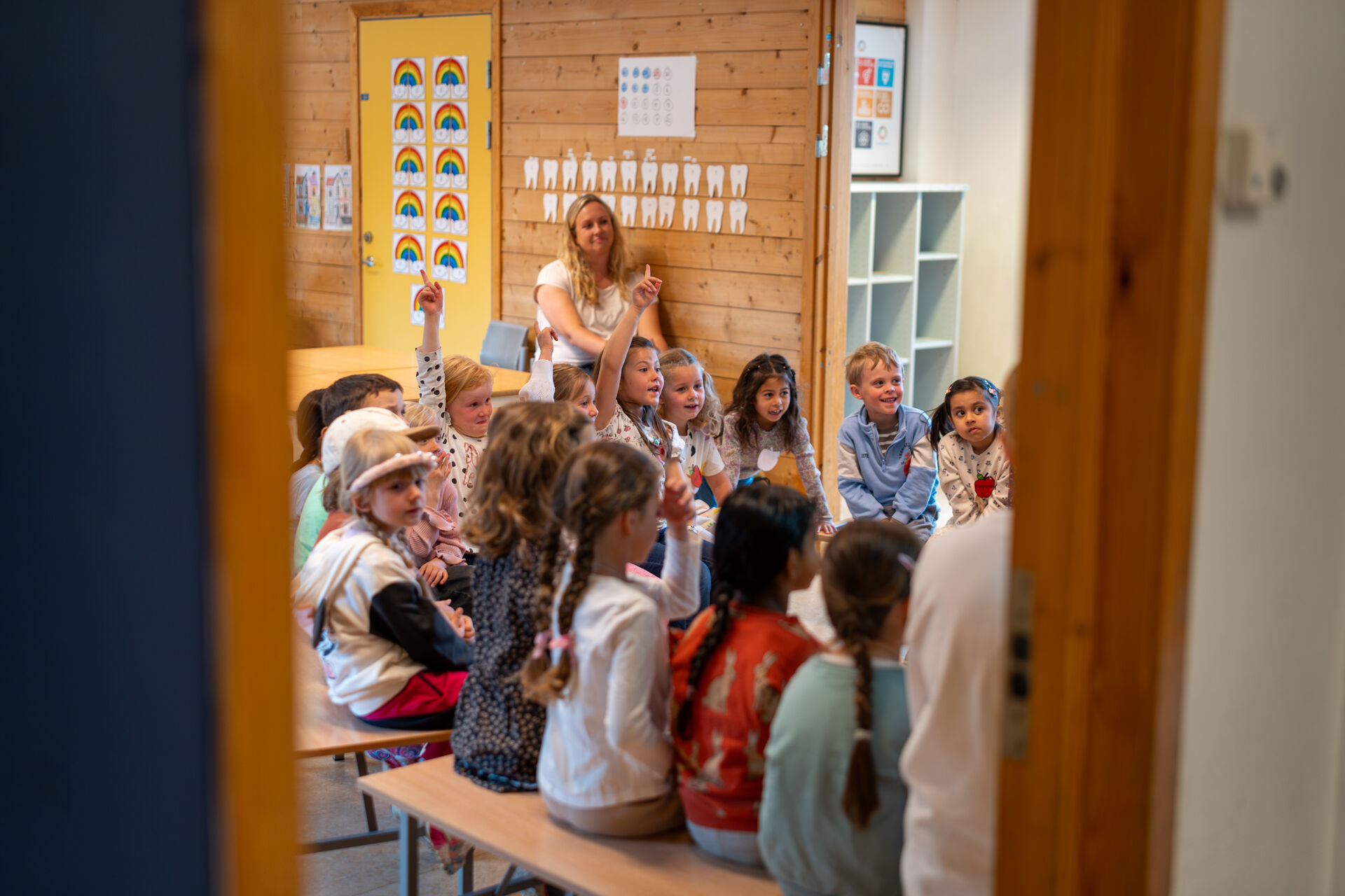 Skolestarterne er samlet i klasserommet. Erika med flere rekker opp hånden.