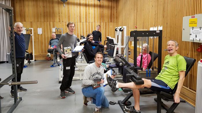 Bilde av flere eldre som trener styrketrening i et treningsrom