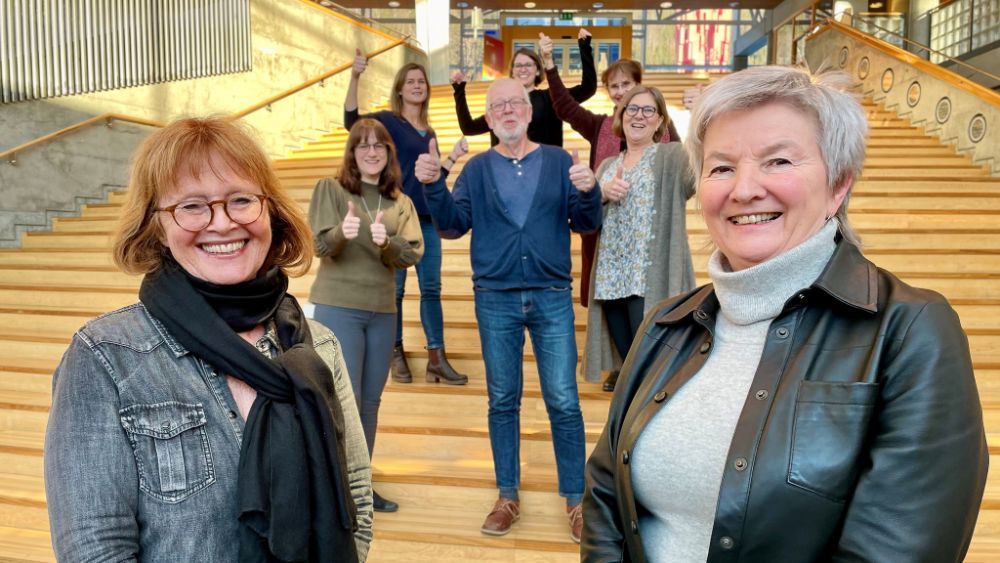 Photo of Karin Julsrud and Ingrid Guldvik in front of a happy bunch with thumbs up.