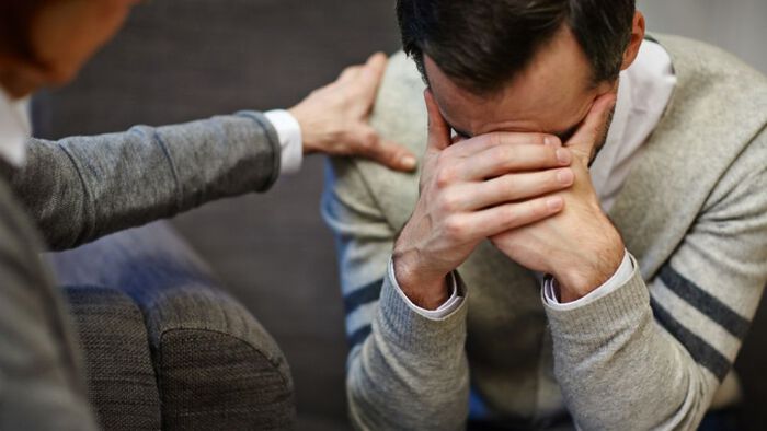 Bilde av mann med hodet i hendene hos psykolog