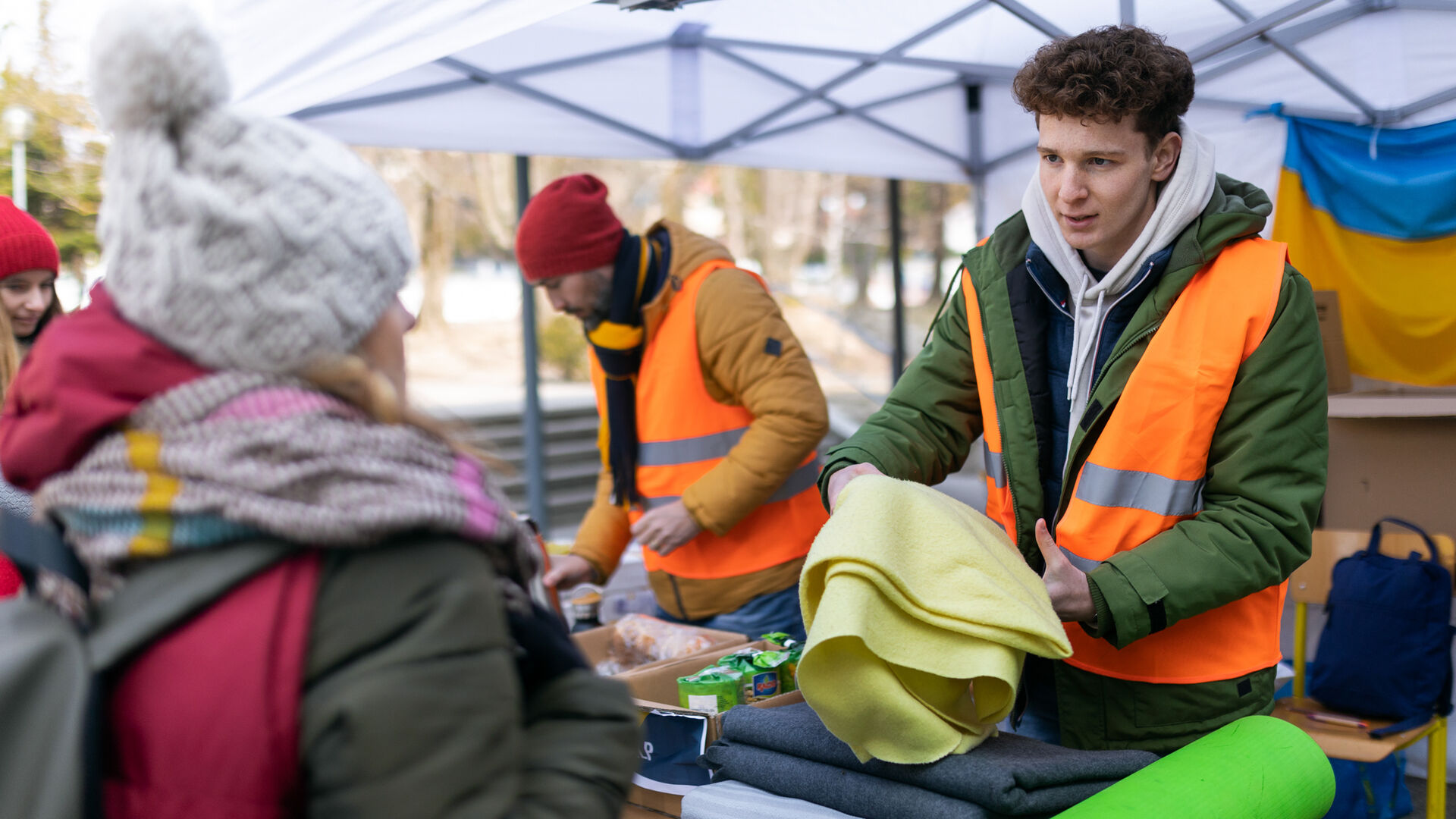 Gutt med relfeksvest deler ut ulltepper på grensa ved ukraina