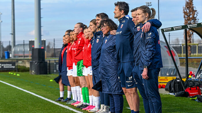 Fleire fotballspelarar på ei rekke langs sidelinja
