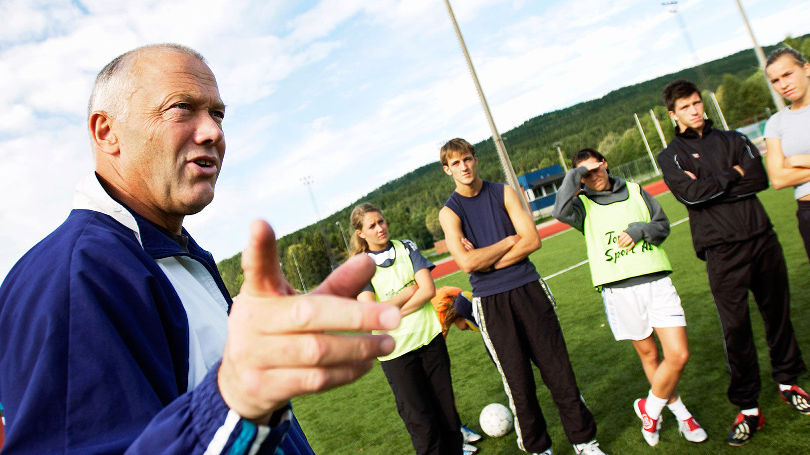 Mann snakker til fotballspillere på trening
