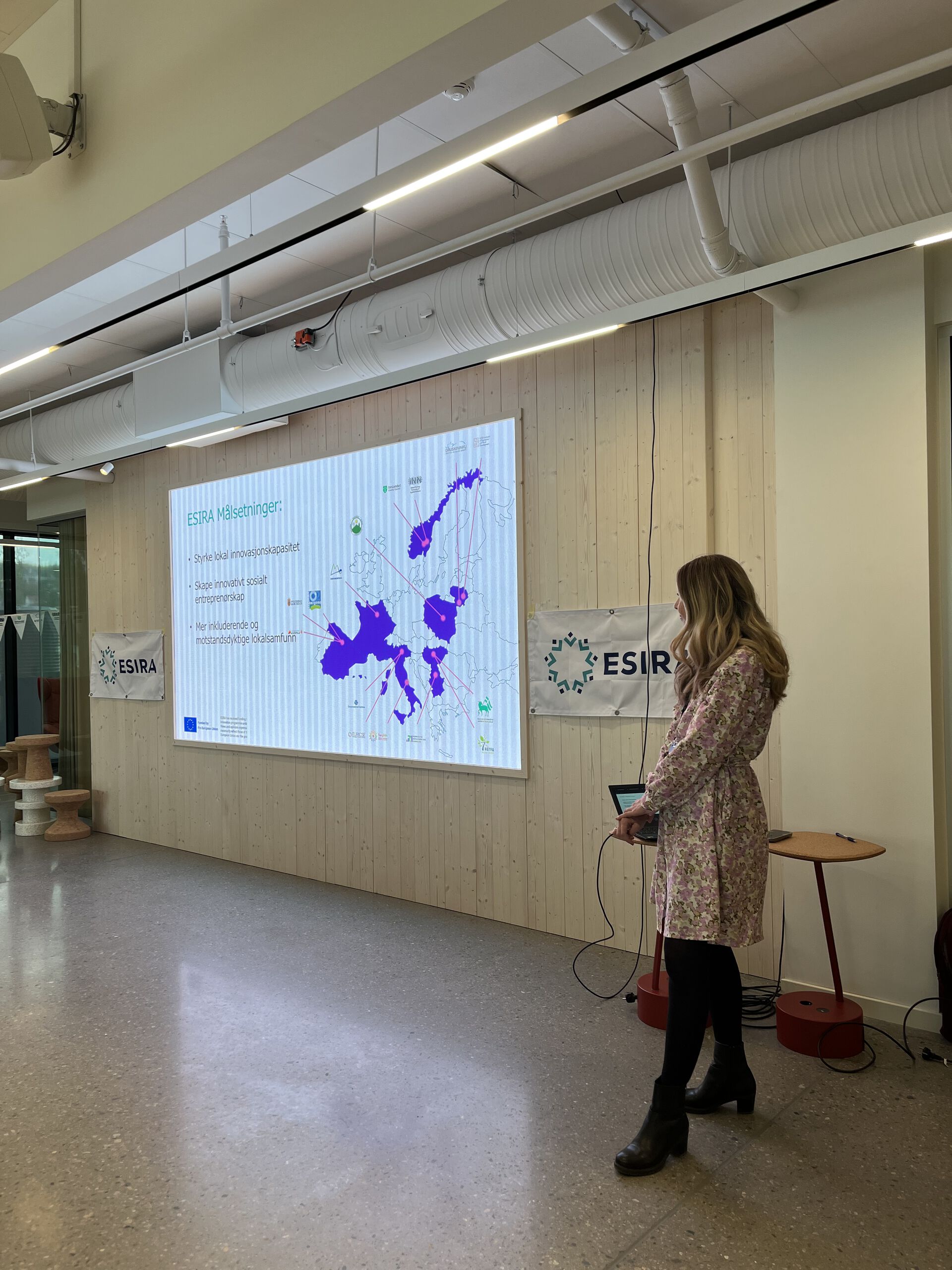 dame i kjole foran en power point presentation om prosjekt ESIRA