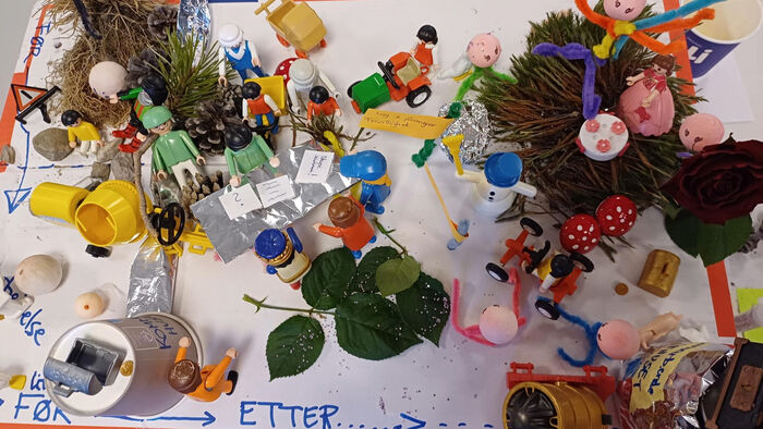 forskjellige materialer som playmobile, piperensere, kongler, blader og lego blir brukt til å bygge en prototype av fremtidens Os kommune
