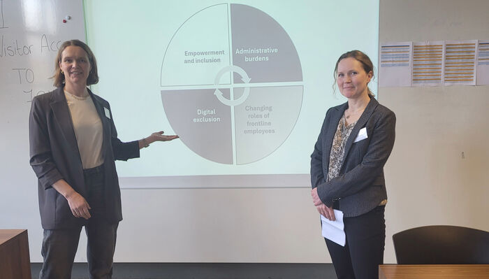to damer foran et stort presentasjonsskjerm