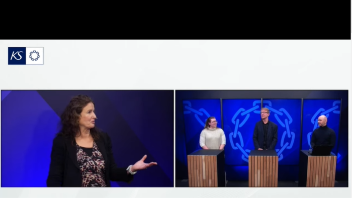 en dame intervjuer tre personer som er stilt opp bak tre talestoler. 