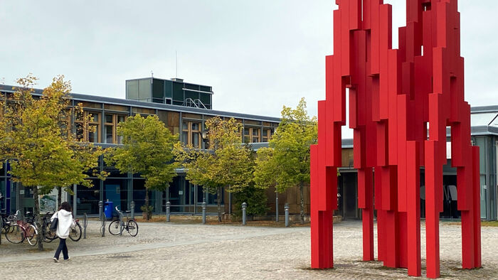 Inngangspartiet og en rød skulptur utenfor høgskolens studiested på Lillehammer