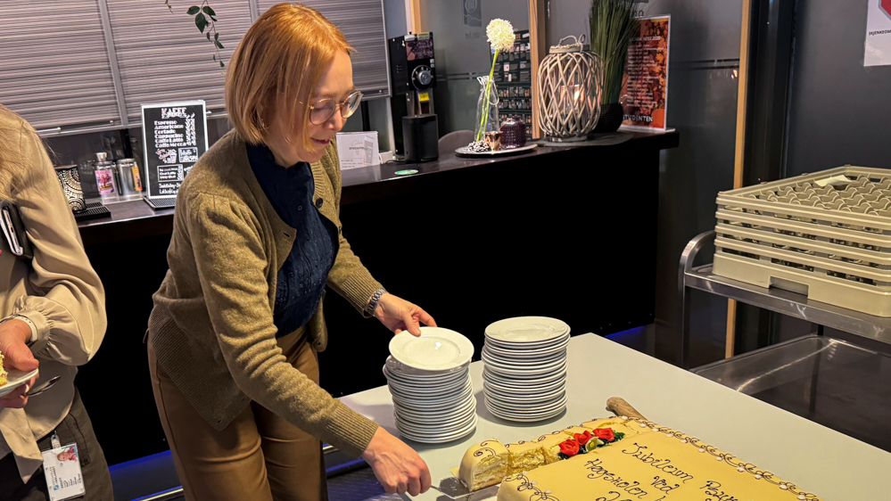 Instituttleder Ingeborg Olsdatter Busterud Flagstad forsyner seg av jubileumskaka. 