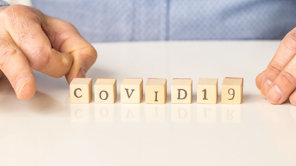 Bokstavklosser som danner ordet covid 19 plassert på et bord