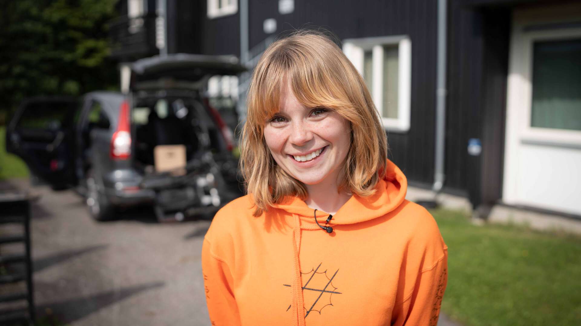 Smilende kvinne i oransje t-skjorte. 