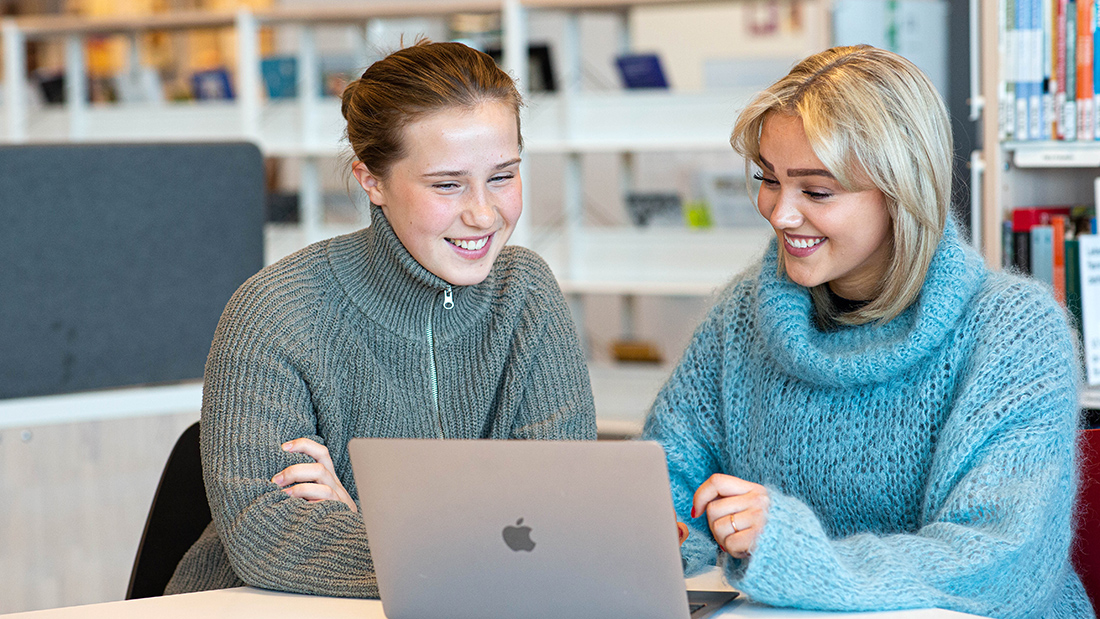 To kvinnelige studenter som ser på en dataskjerm. 