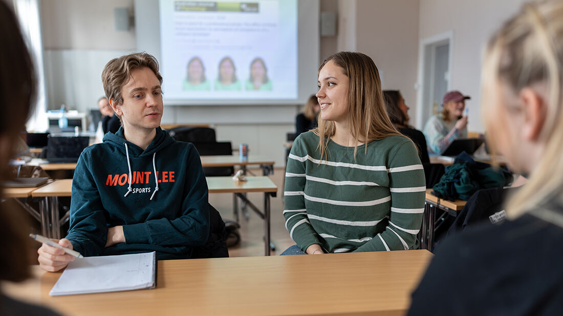 Studenter som sitter rundt et bord og jobber med en oppgave.