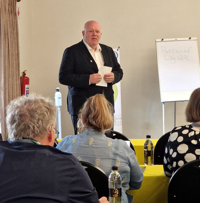 Rektor Peer Jacob Svenkerud står foran en gruppe mennesker i et styremøte