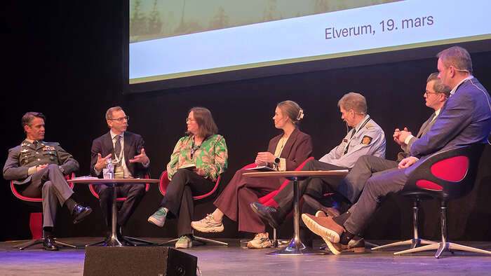 Mennesker i en panelsamtale på en scene. 