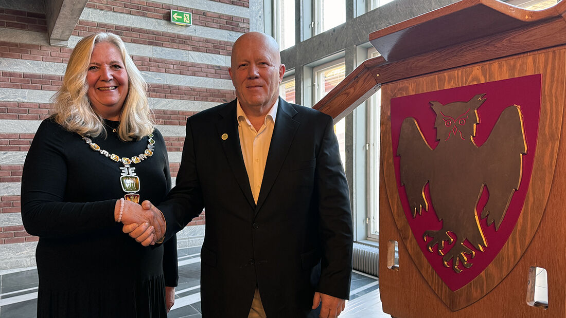 Mann og kvinne i pene antrekk som håndhilser. 