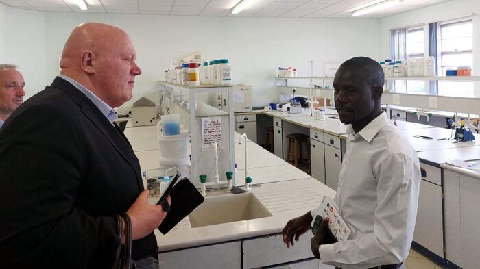 Tre personer på omvisning i et laboratorium