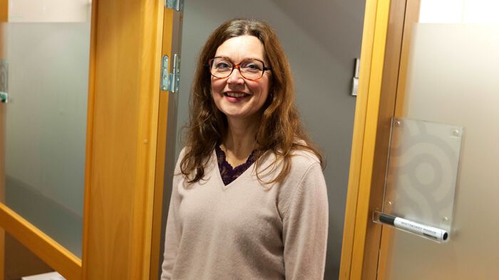 Prorektor for forksning og utvikling Marit Sletmoen står utenfor en kontordør