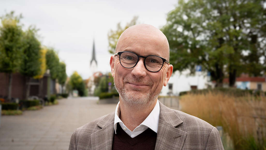 Portrettbilde av en mann i grå dress.
