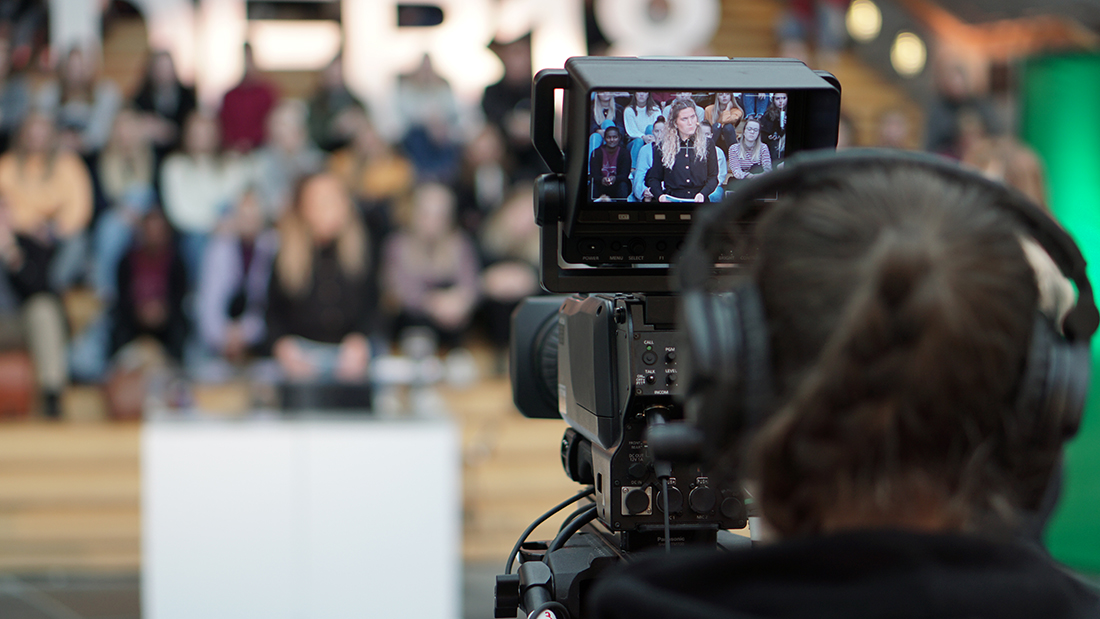 TV-student som filmer en folkemasse på Storhove. 