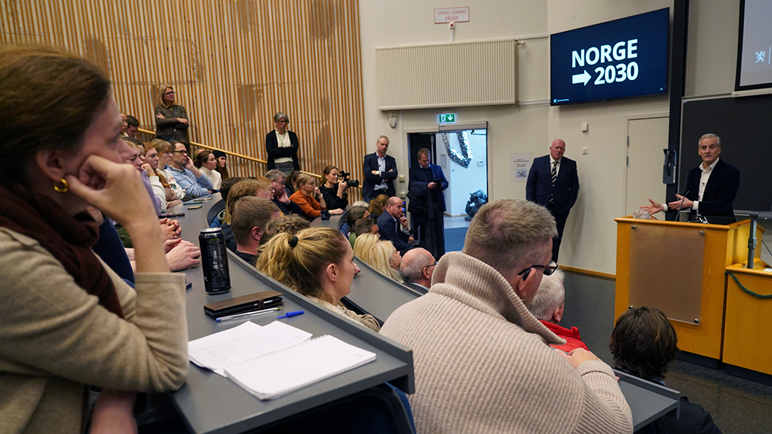 Student som stiller et spørsmål i en forelesningssal. 