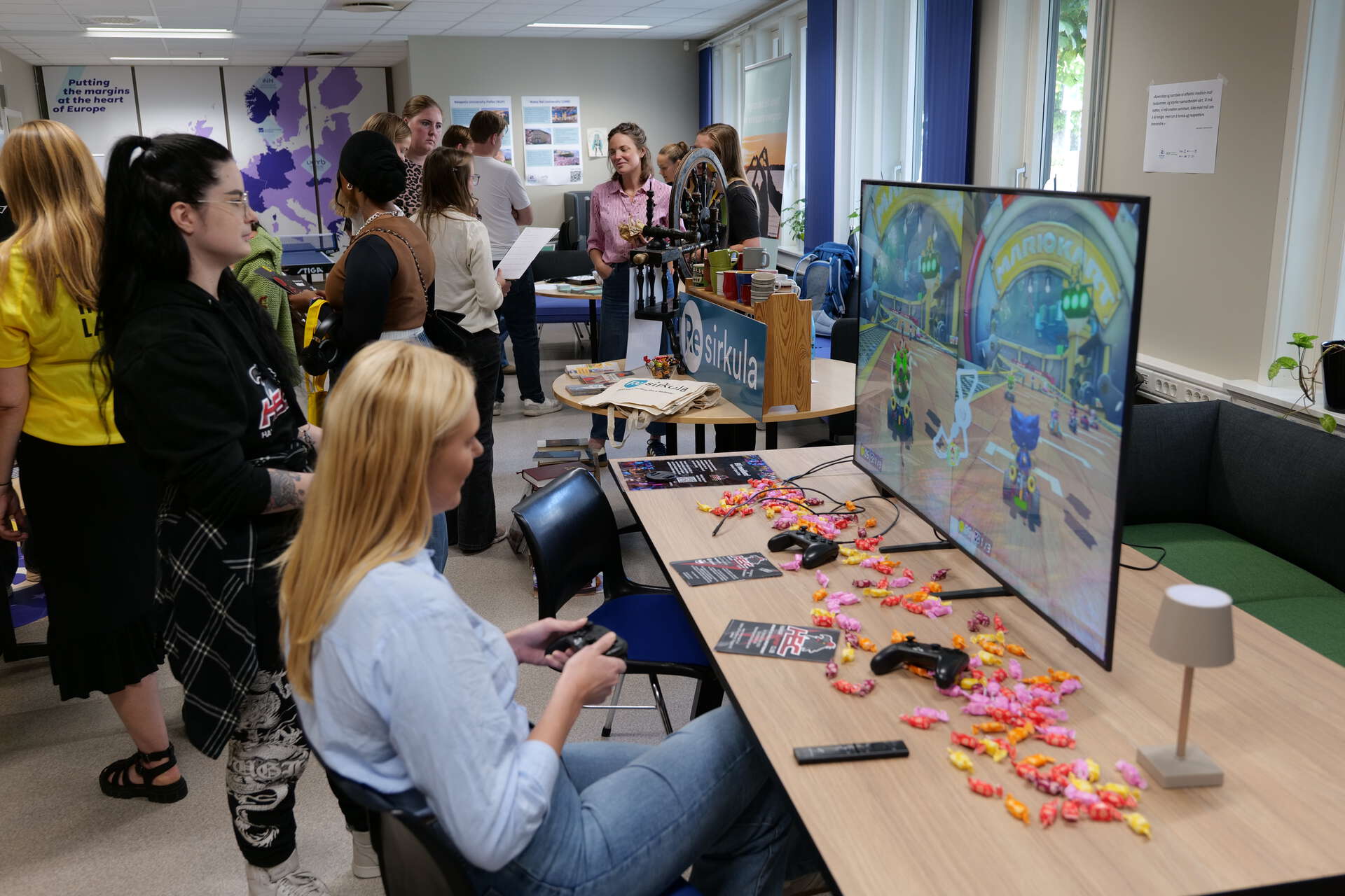 En person sitter og gamer ved en stand