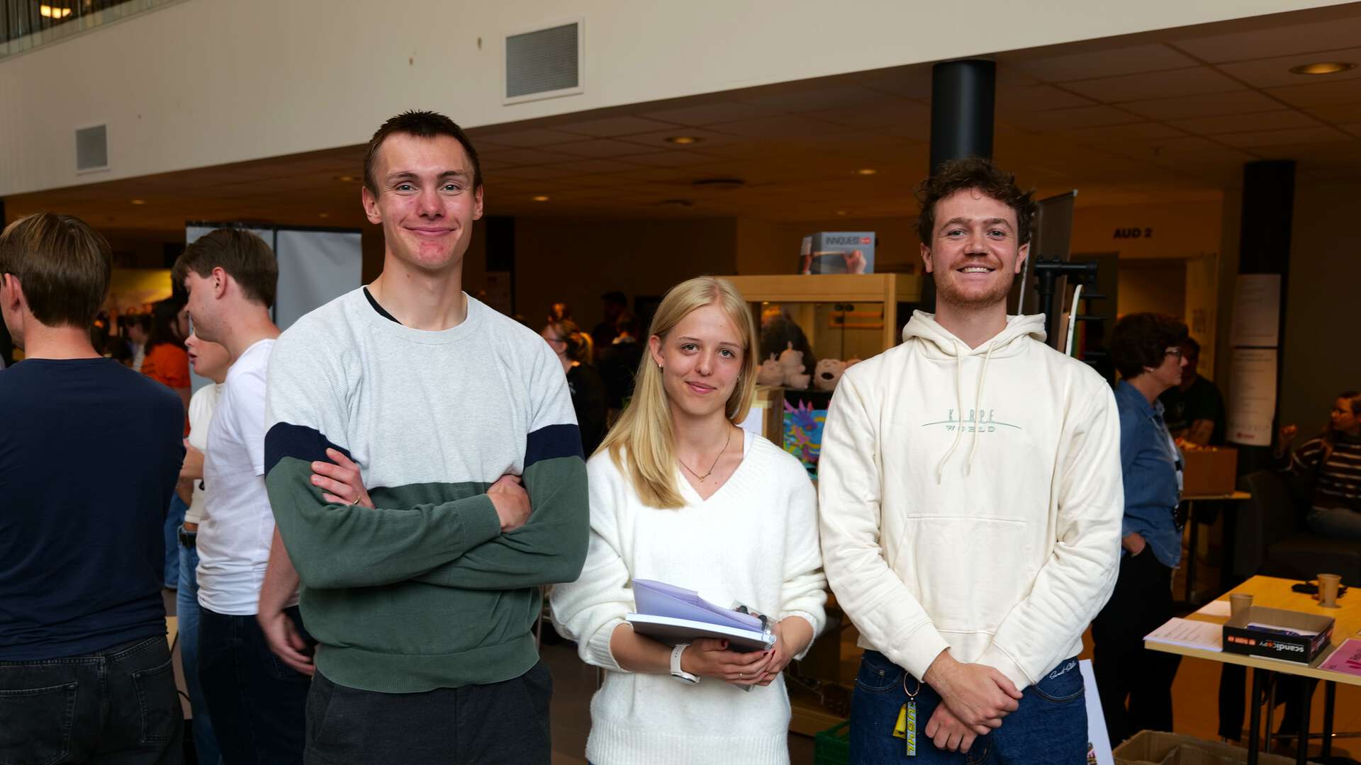 Tre studenter smiler til kamera