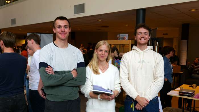 Tre studenter smiler til kamera