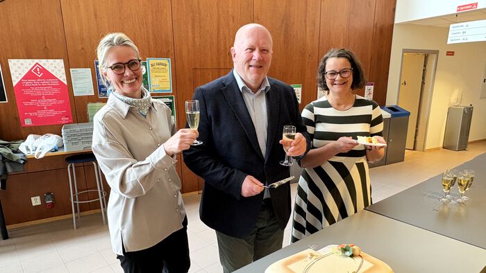 Prorektor utdanning, rektor og institusjonskoordinator feirer EMERGE med bobler og kake. De smiler til kamera