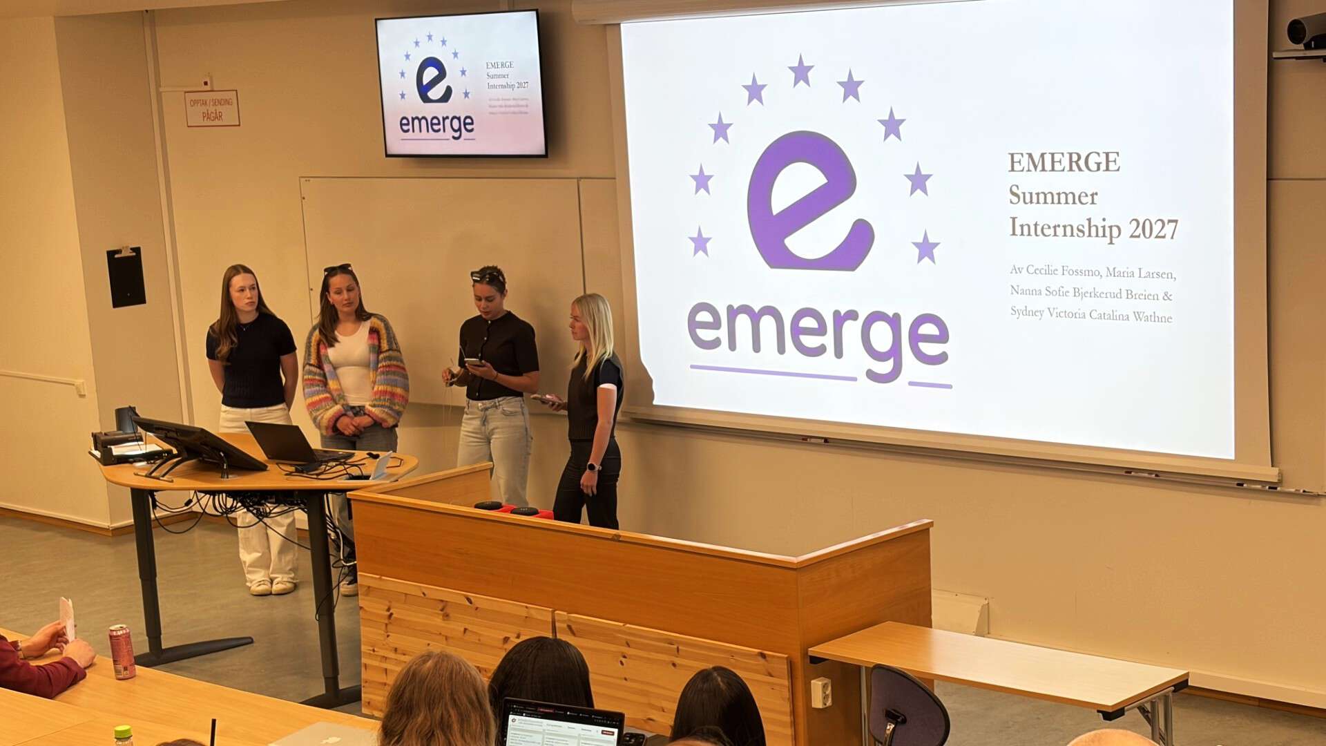 fire studenter presenterer i et auditorium