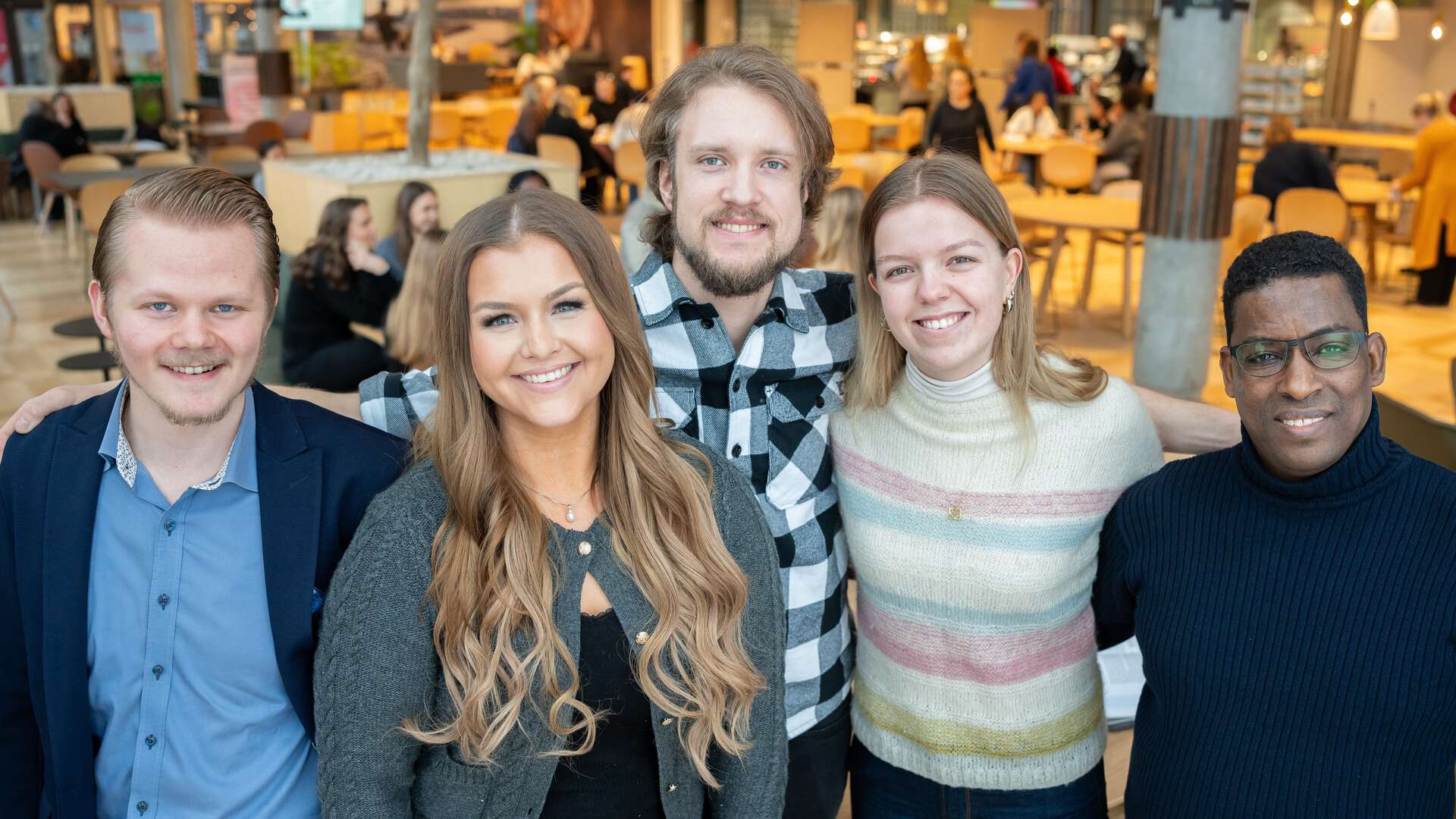 fem studenter smiler til kamera