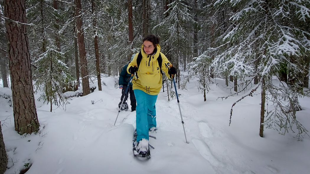 Student on snowshoes through the forest
