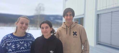 Tre studenterer står ved siden av hverandre. I bakgrunnen kan du se fjellene.