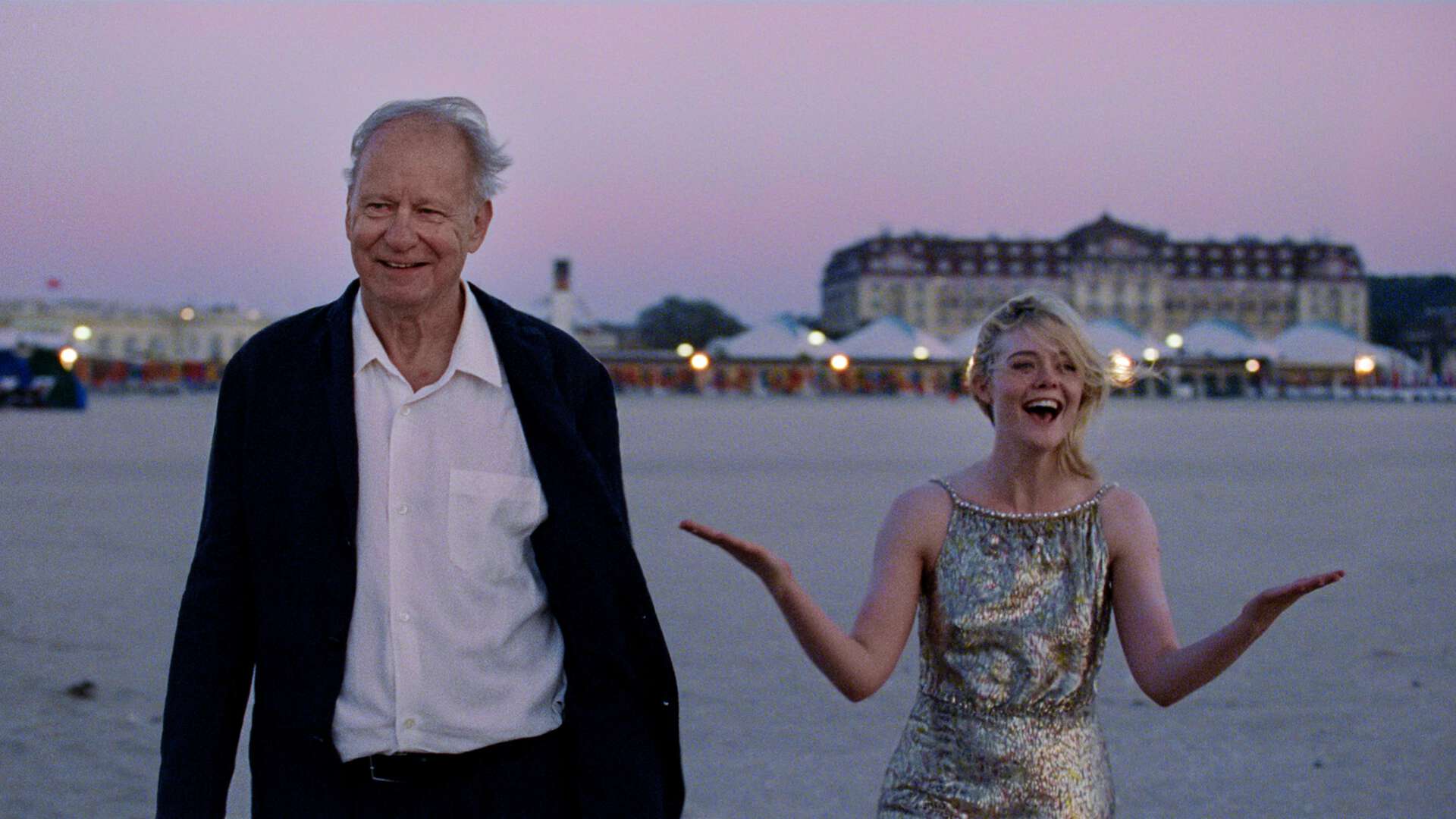 Bilde fra film: Stellan Skarsgård og medspiller smilende på strand.