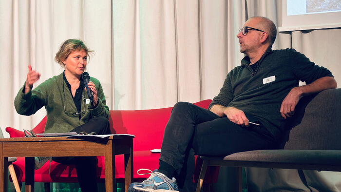 Sara Johansen sitter i en sofa og holder en mikrofon, Audun Engelstad sitter i en stol ved siden av