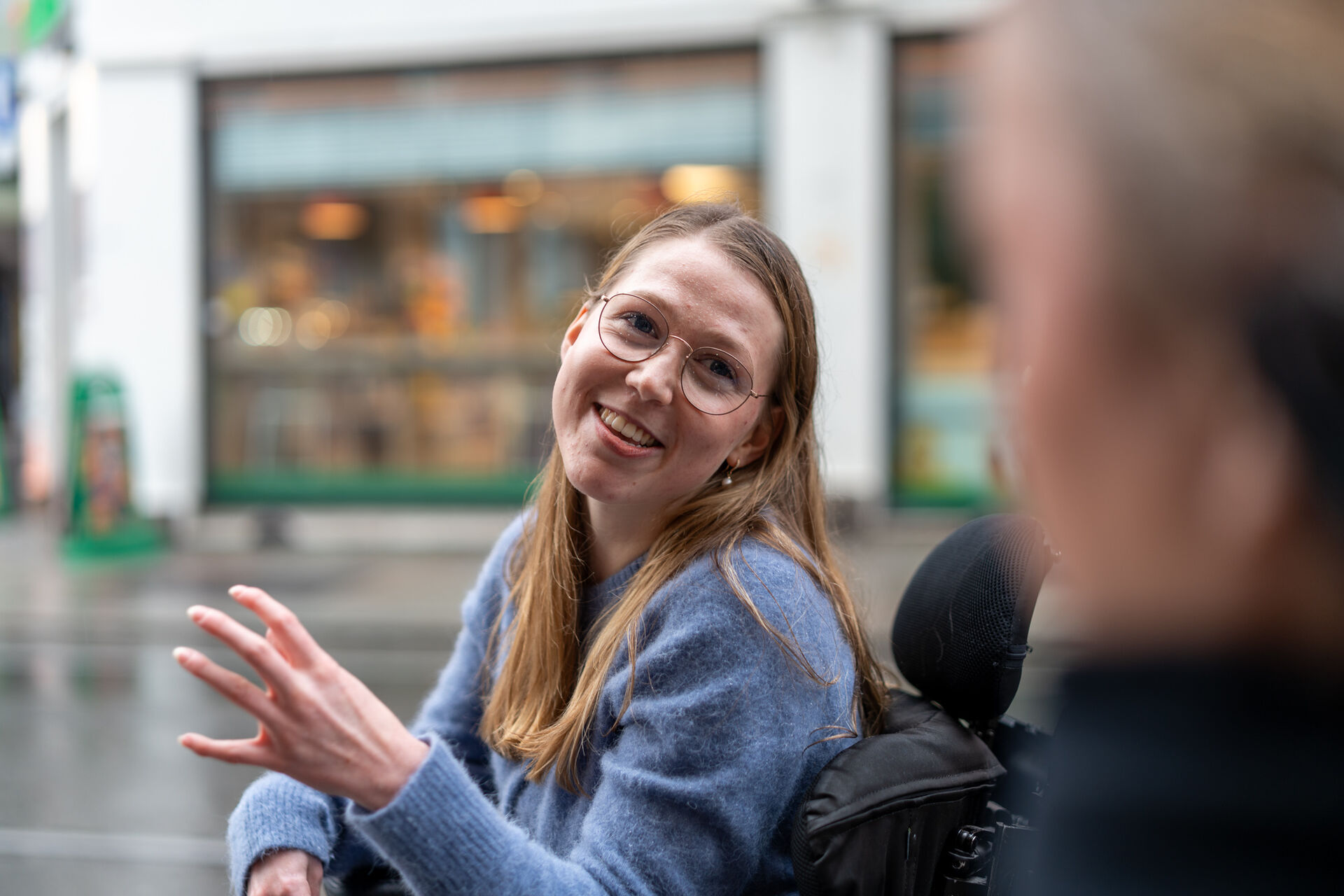Marie smiler mens hun snakker med uklar person til høyre i bildet.