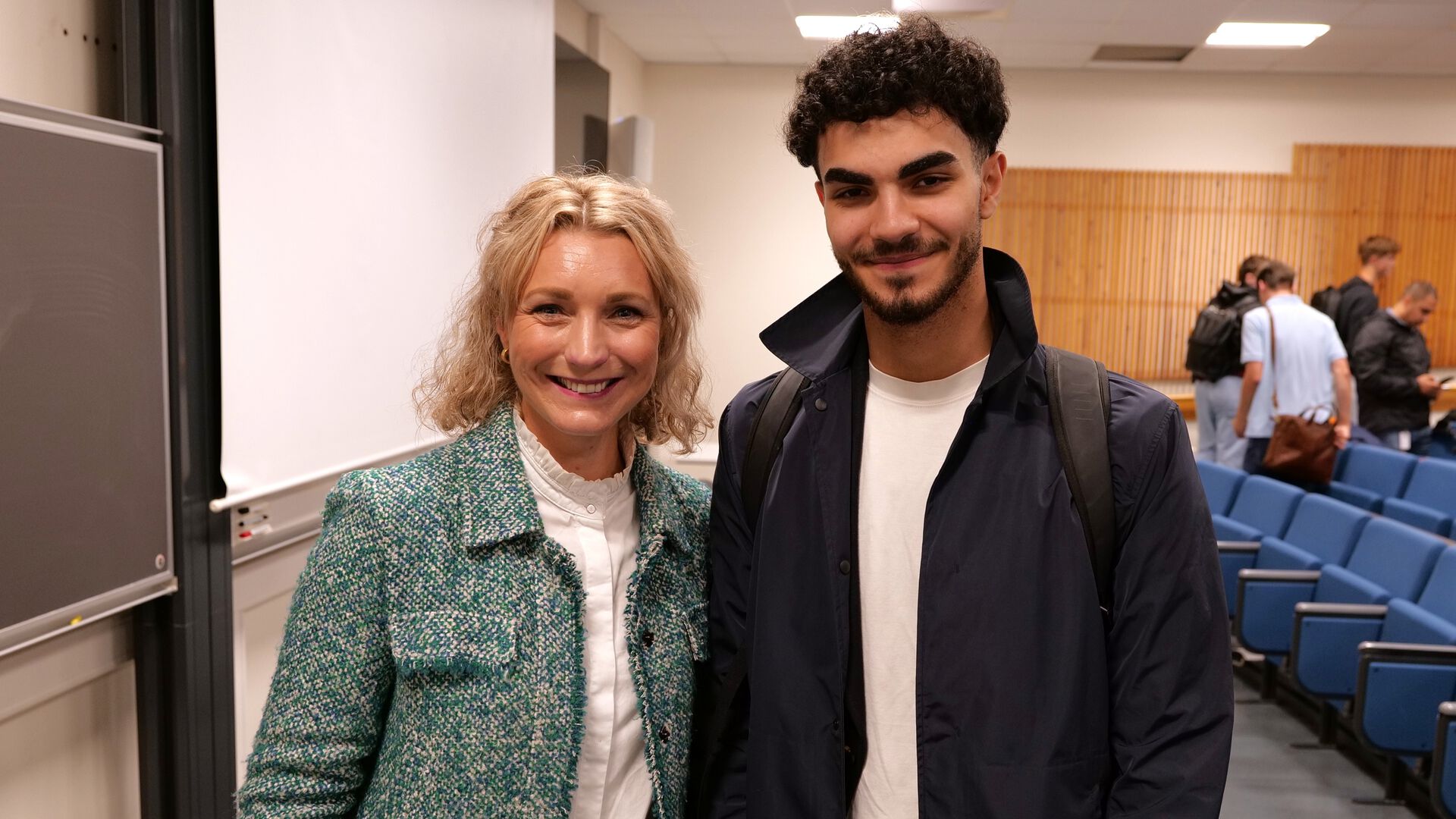 Digitaliseringsministeren poserer i undervisningsaulaen sammen med en student