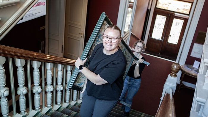 Studenter som bærer skillevegger oppover en trapp i Gamlebanken på Lillehammer