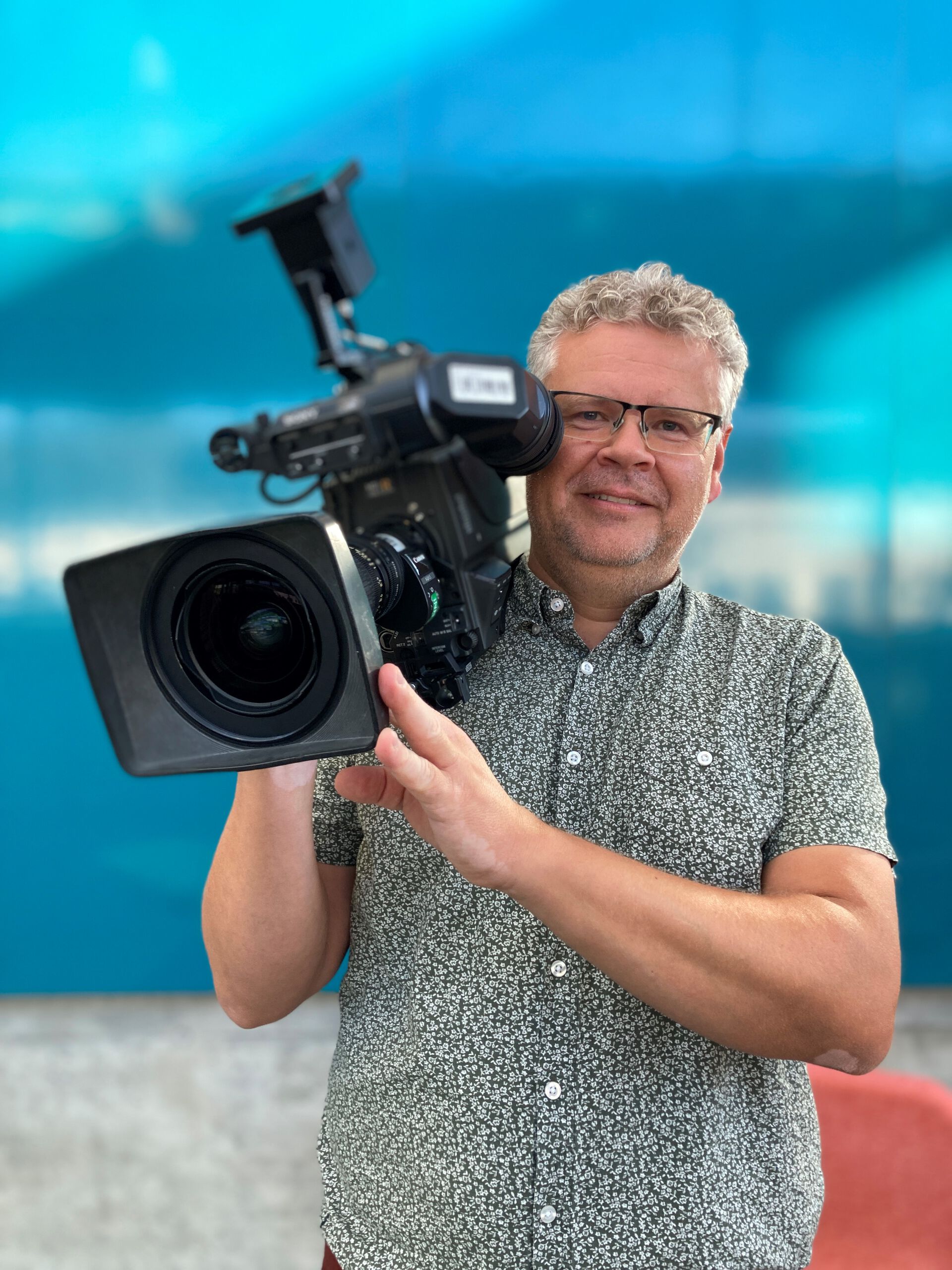 Portrett av Kristian Juliebø som holder et kamera