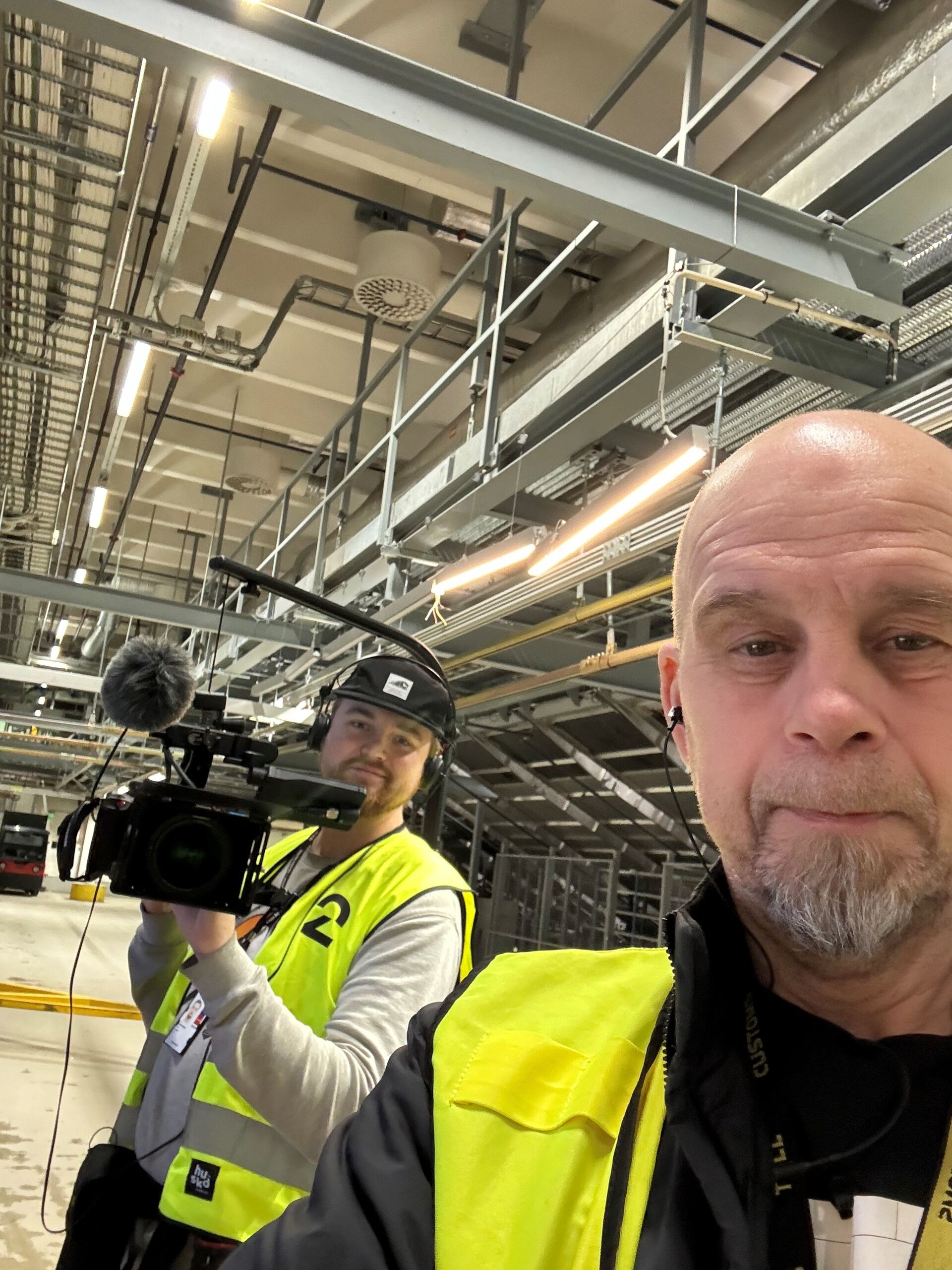 Selfie av Tollern i gul vest med fotograf i bakgrunnen. 