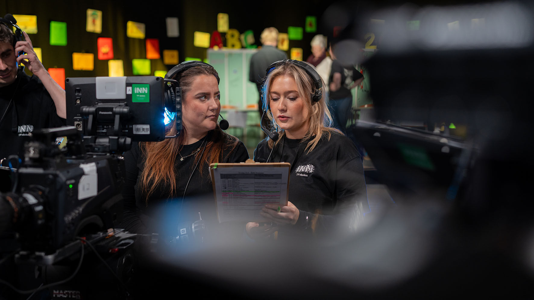 To TV-skolestudenter i studio som diskuterer dagsplanen