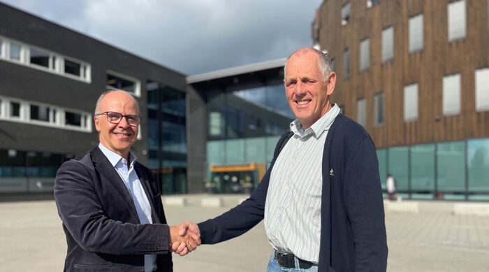 Inge Brechan, Dekan ved HINN, og Administrerende direktør ved Hernes Institutt, Ole Jo Kristoffersen, tar hverandre i hendene og smiler utenfor Terningen Arena etter signert avtale
