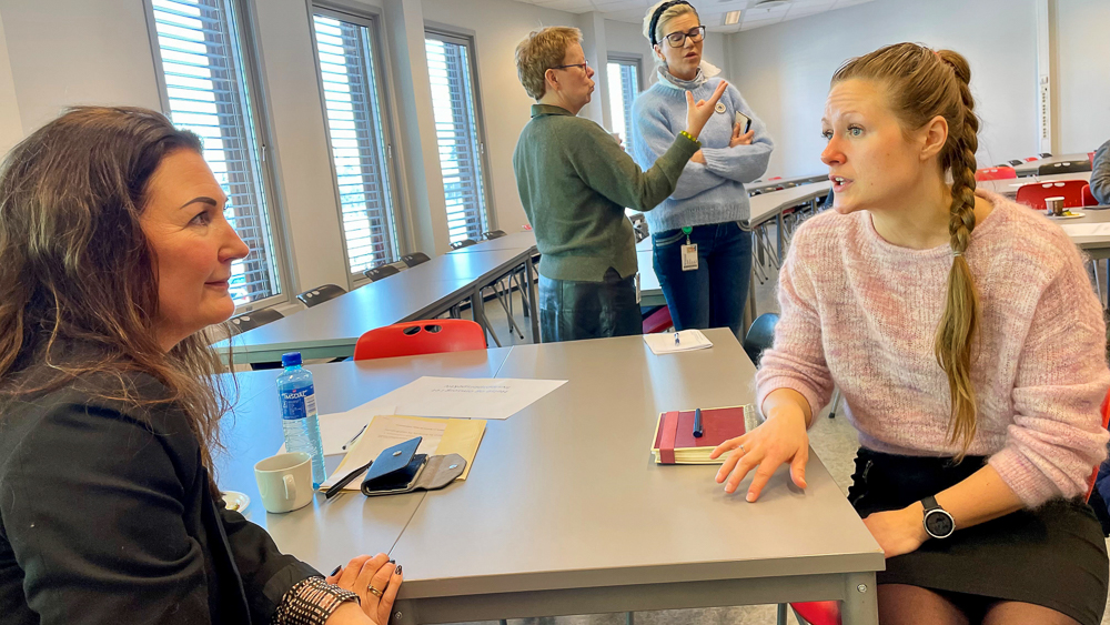 To forskere sitter og snakker ved et bord