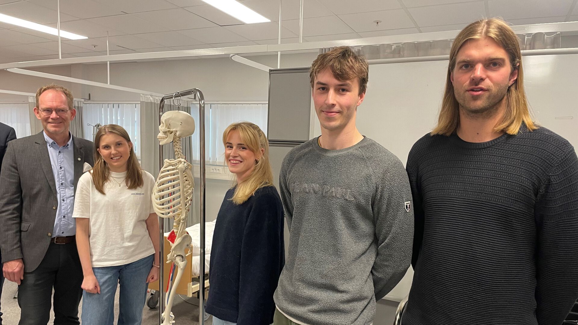 Ministeren i søyvingsavdelingen sammen med fire fysioterapistudenter og et skjelett som henger på et stativ sammen med dem